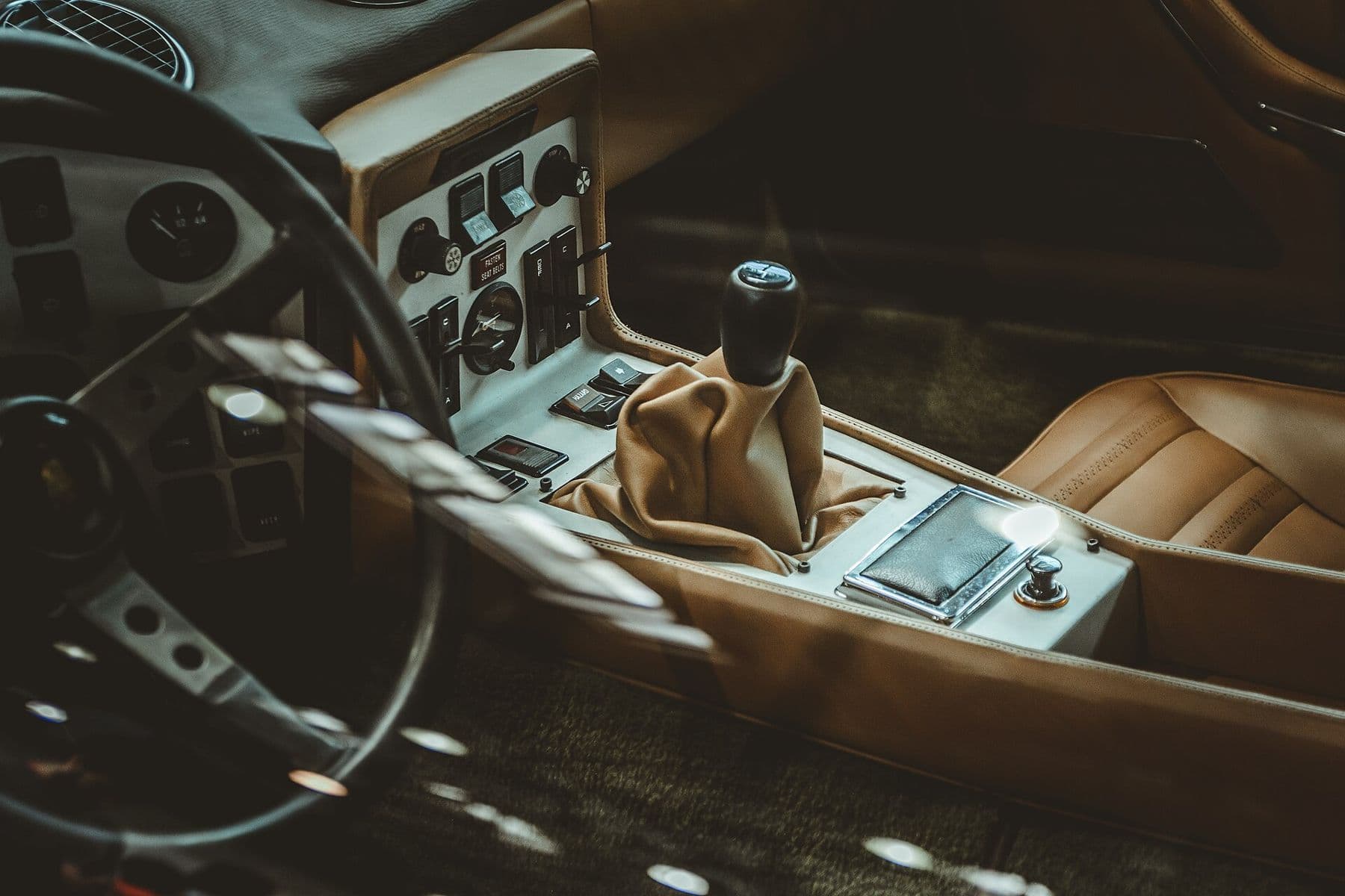 Tan leather seat and gear gaiter in a classic sports-car cockpit