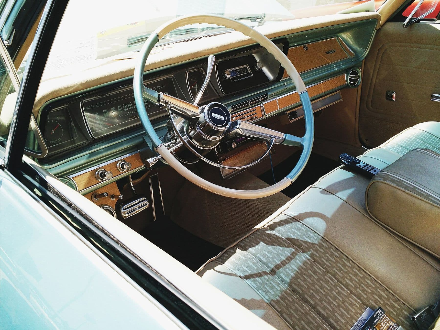 Pale blue classic sedan interior with tan leather bench seat and slim steering wheel